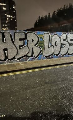 a man riding a skateboard down the side of a wall covered in graffitti