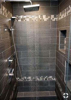 a walk in shower sitting inside of a bathroom next to a tiled wall and floor