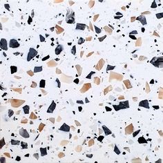 a white and black speckled surface with small pieces of glass embedded in the top