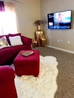 a living room filled with furniture and a flat screen tv mounted to the side of a wall