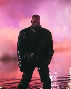 a man standing in the water wearing all black