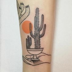 a cactus and bird tattoo on the arm