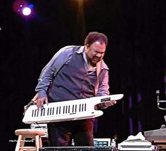 a man standing next to a keyboard on top of a stage