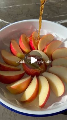 an apple being sliced into slices in a bowl