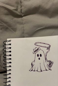 a notebook with a drawing of a ghost on it