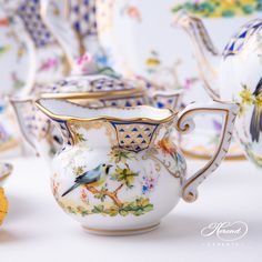 there is a tea set with birds and flowers on the front, along with other dishes