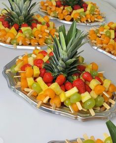 fruit platters with pineapples, oranges, strawberries and grapes