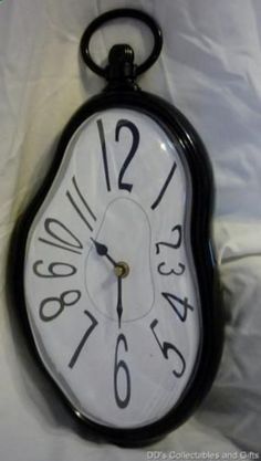 a black and white clock with numbers on it's face sitting on a sheet