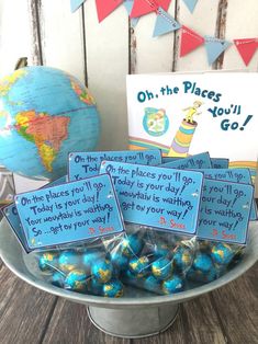 there are some blue and gold candies in a bowl with signs on it that say oh the places you'll go