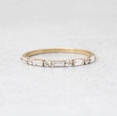 a gold band with three baguets on the side and two small diamonds in the middle