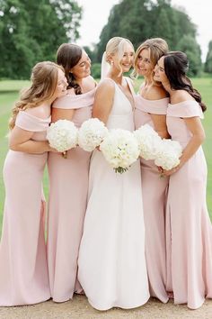 the bride and her bridesmaids pose for a photo together in their pink dresses