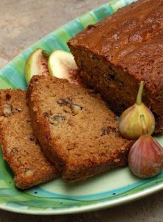 slices of banana bread on a green and white plate with an apple, two pieces of garlic