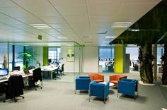 an office with chairs, desks and computers