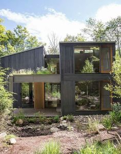 the house is surrounded by trees and plants on both sides of the building's windows