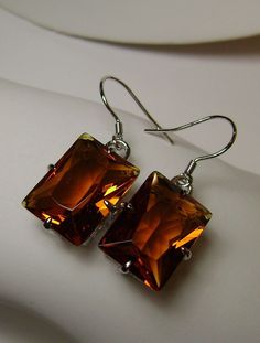 "Simulated Orange Citrine Earrings Rectangle Design #E37 Custom Made This is a brand new beautiful Art Nouveau, vintage-inspired filigree sterling silver pair of earrings. The gorgeous 16 carat weight cognac orange citrine stones are 16mm (5/8\") by 12mm (1/2\"). The earrings are marked 925 for sterling silver. The earrings are 1-5/16\" long. The curves of the filigree give a soft beauty to the elegantly faceted stone. These are classic earrings that will quickly become a favorite to wear. Dress Silver Rectangular Stone Earrings For Formal Occasions, Silver Rectangular Earrings For Formal Occasions, Classic Rectangular Party Earrings, Classic Brown Rectangular Jewelry, Elegant Nickel-free Oblong Earrings, Elegant Oblong Nickel-free Earrings, Orange Rectangular Jewelry As Gift, Classic Earrings With Rectangular Stone For Gift, Classic Rectangular Stone Earrings For Gift