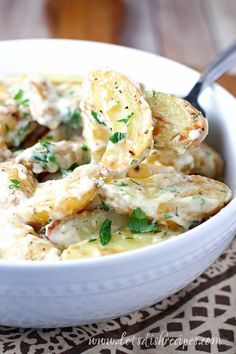 a white bowl filled with potato salad on top of a table