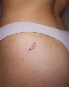 a woman's stomach with a small tattoo on it that has a chili pepper on the side