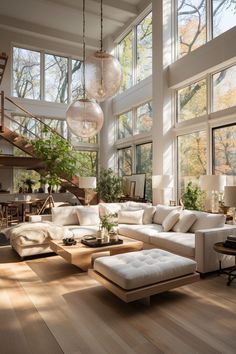 a living room filled with lots of furniture and large windows overlooking the trees in the distance