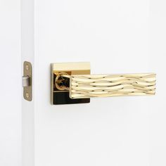 a close up of a door handle on a white door with wood grained design