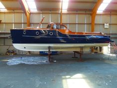 a blue and white boat in a garage