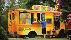 people are ordering food from an orange food truck