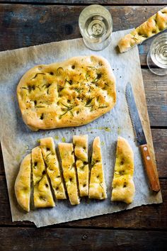 the bread has been cut into slices and is ready to be served with wine glasses