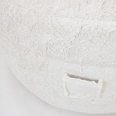 a close up of a white pillow with a hole in the middle on a white background