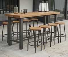 a wooden table with four stools in front of it