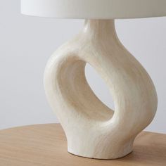 a white table lamp sitting on top of a wooden table