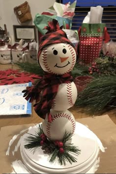 a snowman made out of baseballs sitting on top of a table next to presents