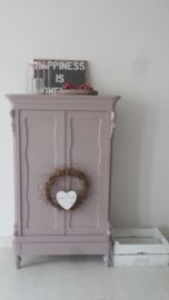 a small cabinet with a wreath on top