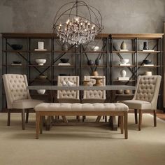 a dining room table with chairs and a bench in front of the bookshelf