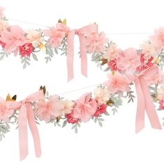 two pieces of pink ribbon with flowers and leaves hanging from the side on a white background