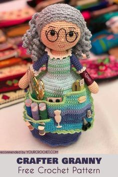 a crocheted doll is sitting in a basket with knitting needles and yarns