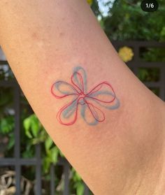 a person with a tattoo on their arm that has a red and blue flower on it