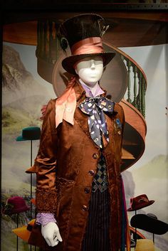 a mannequin dressed in a top hat and coat with a tie on display