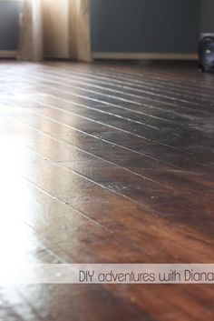 an empty room with wood floors and a speaker on the floor in front of a window