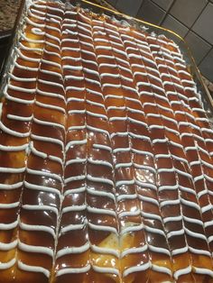 a cake covered in caramel and white icing sitting on top of a pan