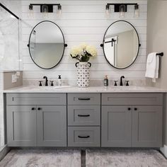 a bathroom with two sinks and mirrors on the wall next to each other in front of a walk in shower