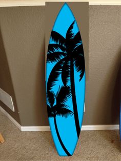 a blue surfboard sitting on top of a carpeted floor next to a wall