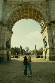 two people standing in front of an archway