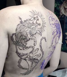 the back of a man's tattoo with an image of a lion on it