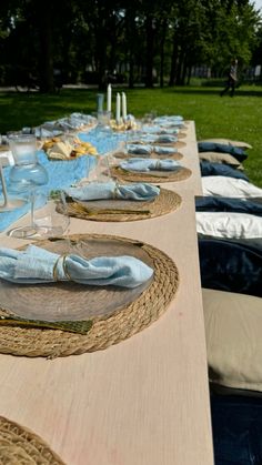 a long table is set up with place settings and napkins for guests to eat