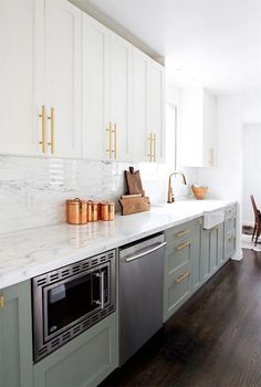 a kitchen with marble counter tops and gold pulls on the cabinets, along with stainless steel appliances