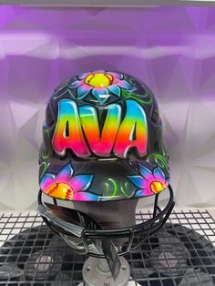 a helmet with the word ava painted on it sitting on top of a metal stand