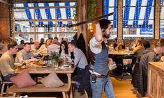 a man holding an umbrella over his head while standing in the middle of a restaurant