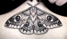 a moth tattoo on the back of a woman