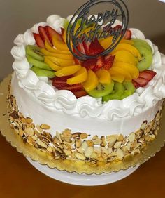 a white cake topped with fruit and nuts