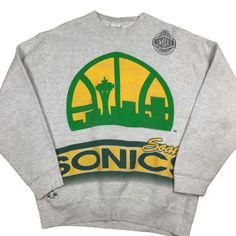 Vintage 90s Seattle Sonics NBA Crewneck sweatshirt. Made in the USA. Double sided graphic. High-quality. Tagged as a large. 22 inches pit to pit, 27 inches long. No rips or tears. Has a couple of light discoloration flaws as shown in last photo. Smoke and pet free home. Rare vintage find! Seattle. Supersonics. NBA. 90s. Urban Graphic Print Sweatshirt For Sports Events, Athletic Heather Sweatshirt With Graphic Print For Streetwear, Urban Crew Neck Sweatshirt For Fan Merchandise, Throwback Crew Neck Sweatshirt For Streetwear, Hip Hop Graphic Print Sweatshirt For Sports Season, Urban Style Crew Neck Sweatshirt For Sports Events, Gray Hip Hop Crew Neck Sweatshirt, Throwback Sports Sweatshirt With Graphic Print, Gray Graphic Print Sweatshirt For Sports Season