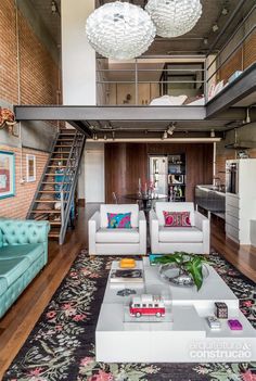 a living room with couches, chairs and a stair case in the back ground